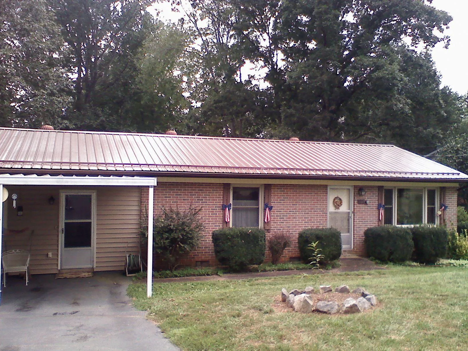 Bronze metal roof and carport on a brick ranch home — Roof Repair work by our crew in Milner